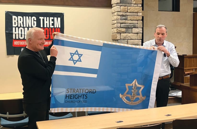  HAMMER presents an Israeli flag to Pastor Ray Phillips (Stratford) (photo credit: Jeremiah Morgan)
