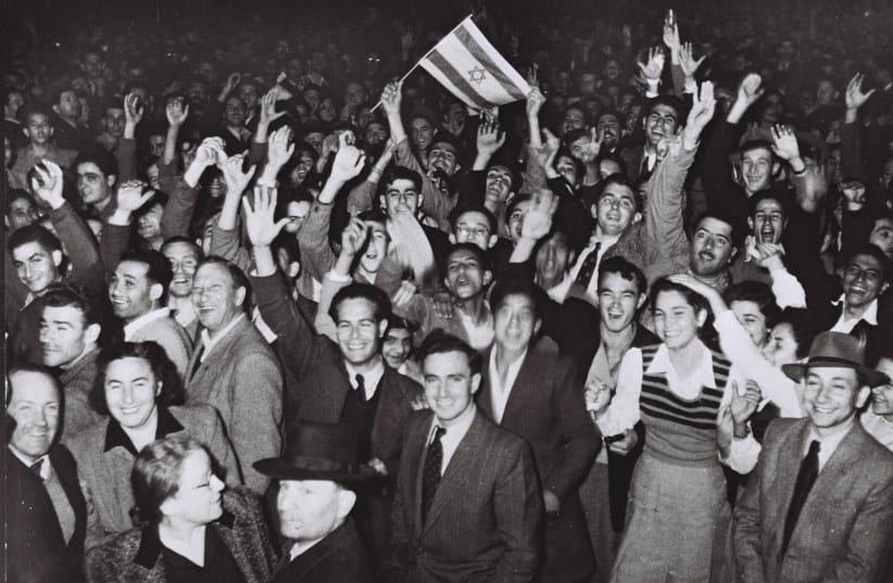  JUBILANT RESIDENTS of Tel Aviv celebrate with what would become the Israeli flag after the UN decision to approve the partition of Palestine, November 29, 1947. (photo credit: Hans Pins/GPO via Getty Images)