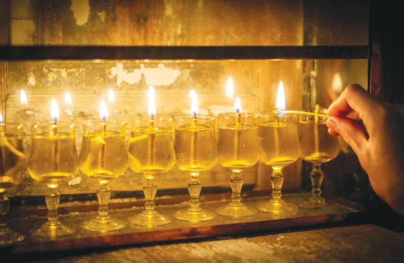  A HANUKKIAH is lit on the eighth night of Hanukkah, last year. The flickering flames serve as a poignant reminder of resilience and faith, says the writer.  (photo credit: YONATAN SINDEL/FLASH90)