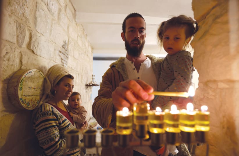  LIGHTING THE fifth candle with oil in Safed.  (photo credit: David Cohen/Flash90)