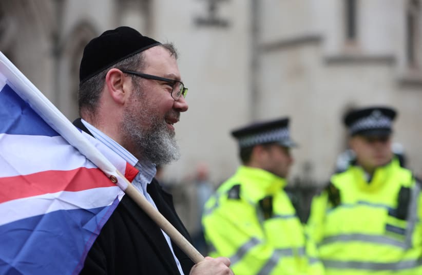  A man, wearing a kippah, holds the British flag at a march against antisemitism, after an increase in the UK, in London, Britain November 26, 2023.  (photo credit: REUTERS/Susannah Ireland)