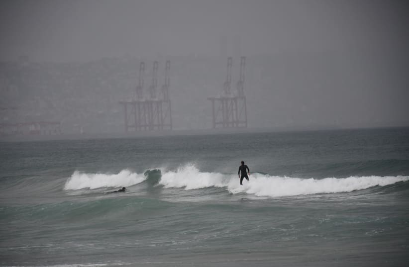 Surfers braved cold water and rain amidst a winter storm as they tried to drop into some waves in Haifa bay on Saturday, December 9. (photo credit: Seth Frantzman)