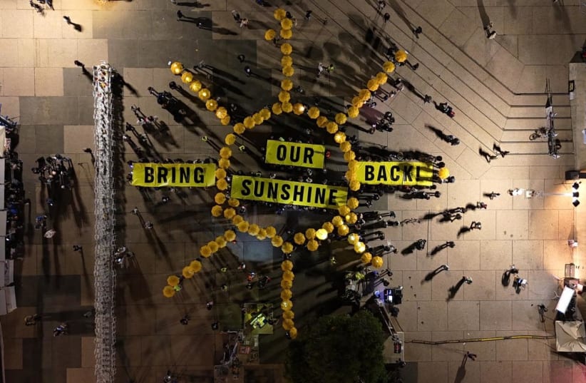 BRING OUR SUNHINE BACK, climate activists gather together to form a sign for the hostages being held captive in Gaza. (photo credit: OFER MERIASH)