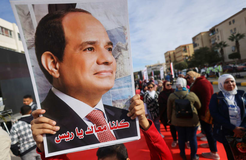  A person carries a picture of Egyptian President Abdel Fattah El-Sisi on the first day of the presidential election in Cairo, Egypt, December 10, 2023.  (photo credit: REUTERS/AMR ABDALLAH DALSH)