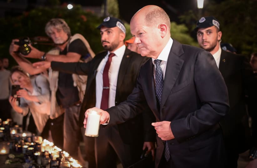  Chancellor of Germany Olaf Scholz lights a candle in memory of the victims who were murdered by Hamas militants, at Dizengoff Square in Tel Aviv, October 17, 2023. (photo credit: AVSHALOM SASSONI/FLASH90)