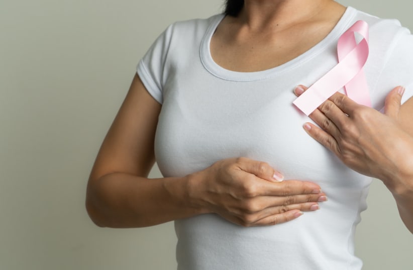  A woman is seen holding a pink ribbon, symbolizing breast cancer awareness. (photo credit: INGIMAGE)