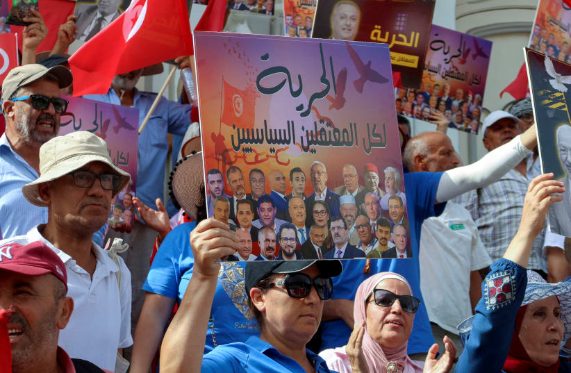 Supporters of Tunisia's Salvation Front opposition coalition carry banners and flags during a protest against Tunisia's President Kais Saied, marking two years since Saied began amassing power, amidst a heatwave in Tunis, Tunisia July 25, 2023 (photo credit: REUTERS/JIHED ABIDELLAOUI)