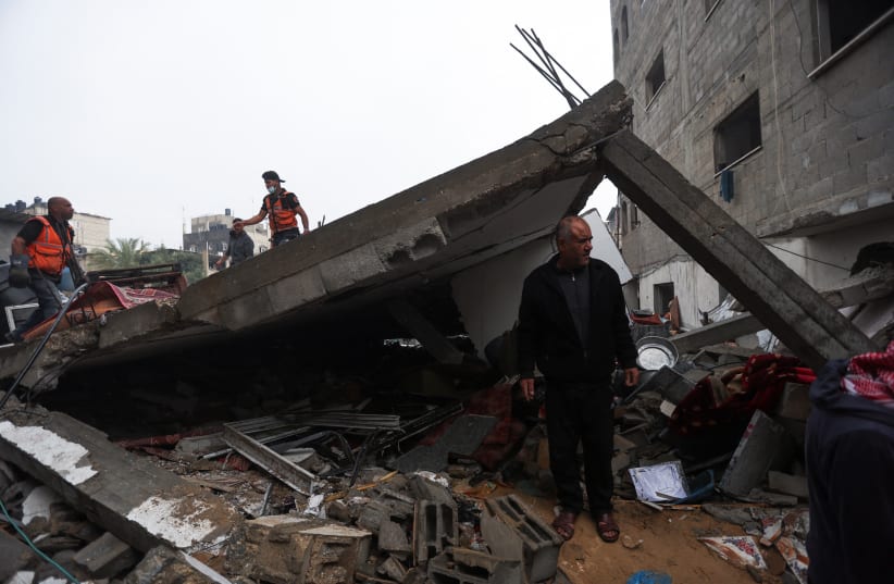  Palestinians inspect the damage at the site of Israeli strikes on houses in Khan Yunis in the southern Gaza Strip, December 13, 2023 (photo credit: REUTERS/IBRAHEEM ABU MUSTAFA)