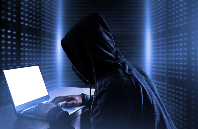  An illustrative image of a person at a computer surrounded by code, indicating hacking or cyberattacks. (photo credit: INGIMAGE)