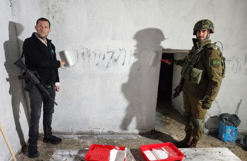  Yossi Dagan (L), head of the Samaria Regional Council, paints over 'Death to Jews' graffiti at the Tomb of Joshua bin Nun, December 13, 2023 (photo credit: ROI HADI)