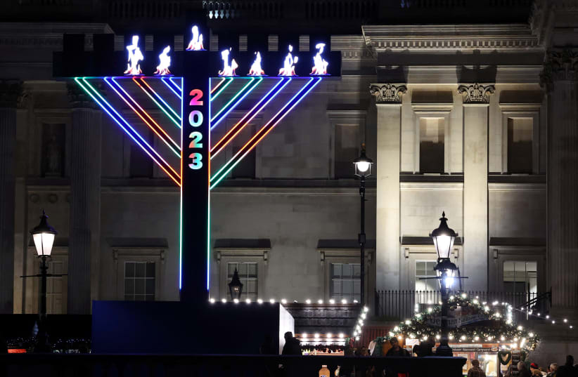  Visitors view a menorah illuminated for the Jewish festival of Hanukkah, forming a seasonal light display in Trafalgar Square in London, Britain, December 12, 2023. (photo credit: TOBY MELVILLE/REUTERS)