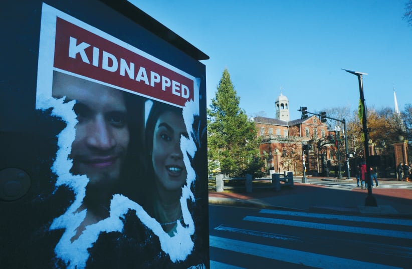  A POSTER of people taken hostage during the October 7 Hamas attack on Israel is torn, outside the gates of Harvard University.  (photo credit: BRIAN SNYDER/REUTERS)