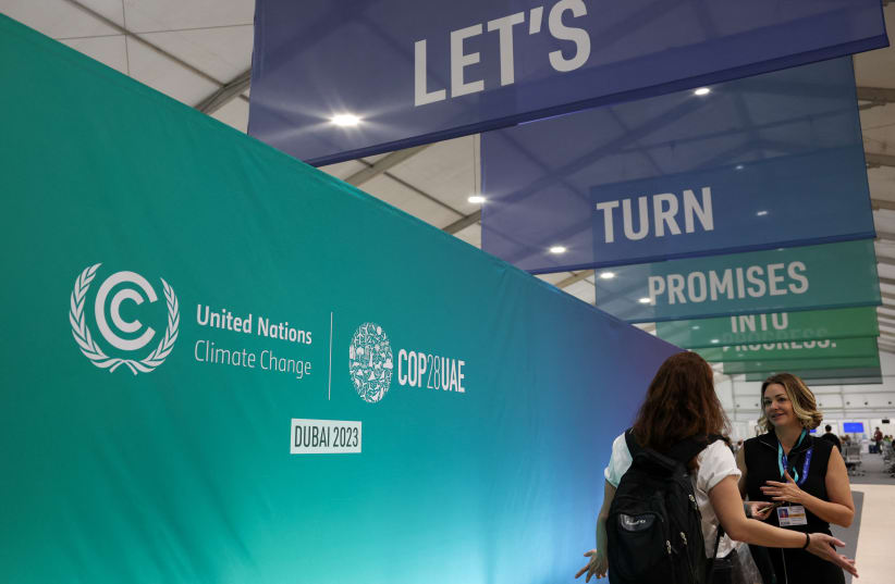  People talk at the venue, as draft of COP28 deal is negotiated at the same time, during the United Nations Climate Change Conference (COP28) in Dubai, United Arab Emirates, December 12, 2023. (photo credit: Amr Alfiky/Reuters)