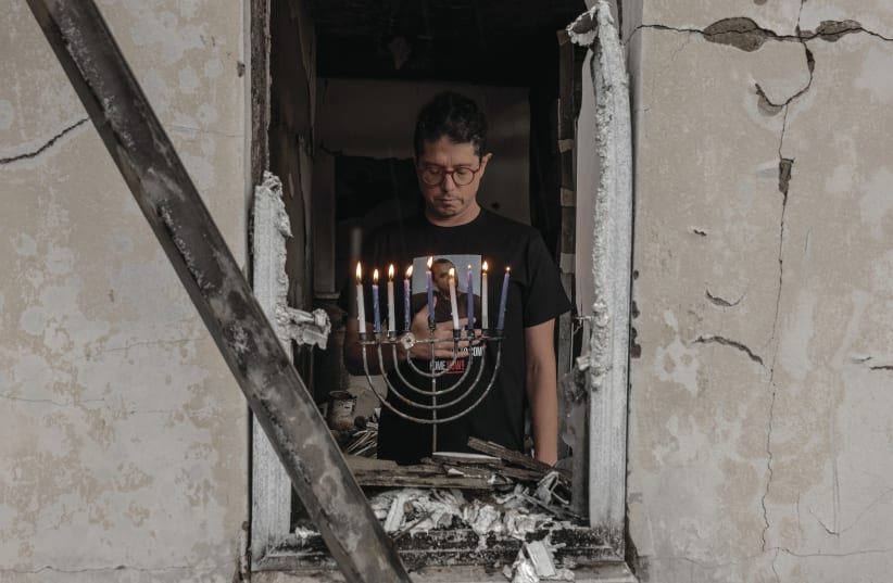  ‘A POWERFUL reminder of the resilience and hope that dwell within us all.’ Yuval Haran, a resident of Kibbutz Be’eri, returned to his home this week and lit a hanukkiah that was retrieved from the rubble.  (photo credit: CHEN SCHIMMEL)