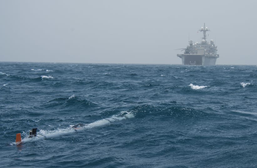 An unmanned underwater vehicle (UUV) submerges during International Mine Countermeasures Exercise (IMCMEX) 13 as the Afloat Forward Staging Base (Interim) USS Ponce (AFSB(I)15) operates in the background (May. 14, 2013). (photo credit: Mass Communication Specialist 1st Class Daniel Gay/Naval Forces Central Command/WIKIMEDIA COMMONS)