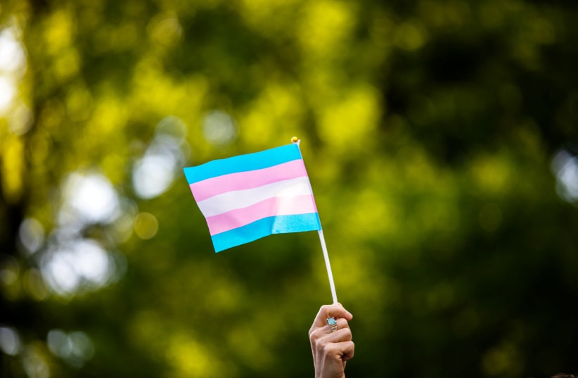  Transgender rights activist waves a transgender flag as they protest the killings of transgender women this year, at a rally in Washington Square Park in New York, U.S., May 24, 2019. (photo credit: REUTERS/Demetrius Freeman)