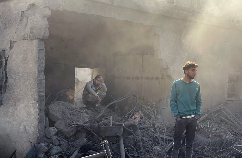  Palestinians react at the site of an Israeli strike on a house, amid the ongoing conflict between Israel and Palestinian Islamist group Hamas, in Rafah in the southern Gaza Strip December 14, 2023. (photo credit: REUTERS/Sami Abu Tabak)