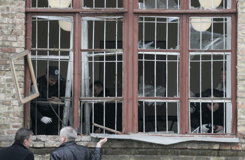 Investigators inspect an office where a grenade exploded in Kiev March 11, 2009. An unidentified attacker hurled a grenade through the window of an office linked to Kiev's main railway station, wounding seven people, Ukrainian security forces said. (photo credit: REUTERS/KONSTANTIN CHERNICHKIN)