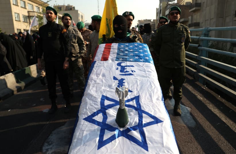  Members of Basij paramilitary forces hold a coffin with the Israeli flag during a rally in support of Palestinians, in Tehran, Iran, November 24, 2023. (photo credit: Majid Asgaripour/WANA via Reuters)