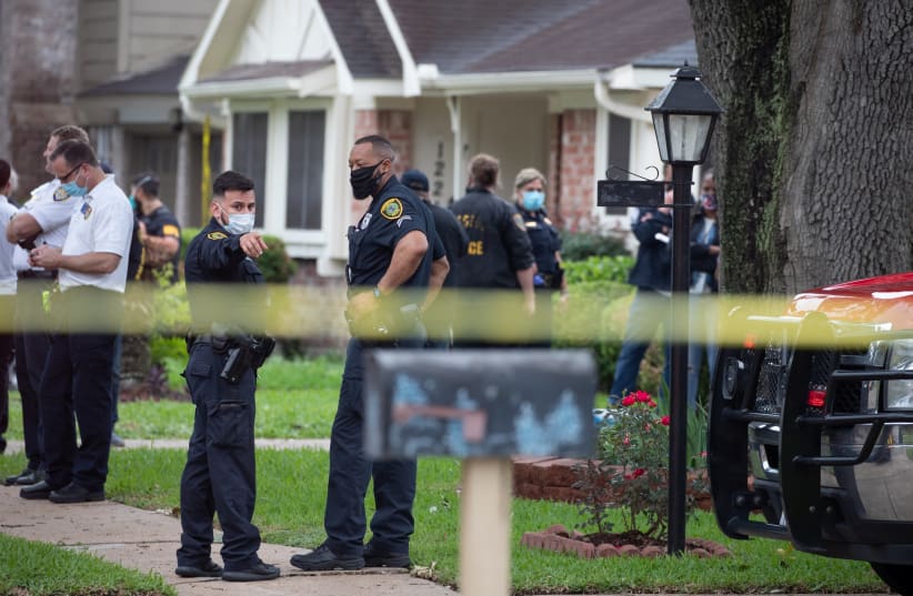 Police officials stand outside 12200 Chessington Drive in southwest Houston, Texas, U.S., April 30, 2021. Dozens of persons were found inside a residence in Southwest Houston, which was initially reported as a kidnapping but prompted police to look into human smuggling, police and local news organiz (photo credit: ADREES LATIF/REUTERS)