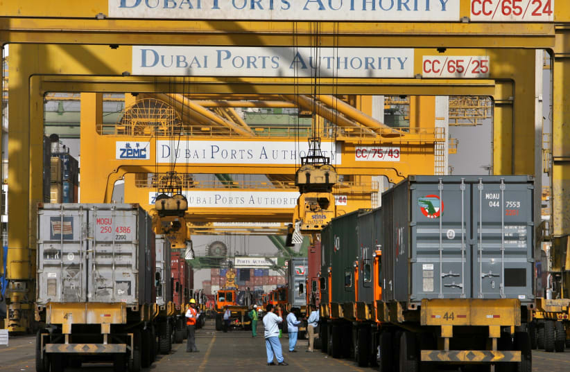  Foreign workers work as trucks queue inside Dubai's port in the United Arab Emirates February 14, 2006. (photo credit: AHMED JADALLAH/REUTERS)