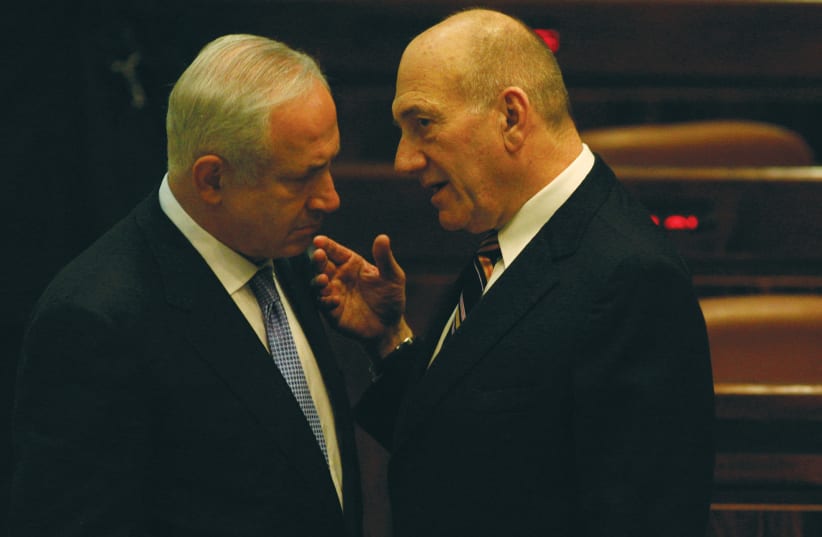  OUTGOING PRIME MINISTER Ehud Olmert speaks in the Knesset to his successor, Benjamin Netanyahu, on the night of the inauguration of the Netanyahu government in 2009. (photo credit: YOSSI ZAMIR/FLASH90)