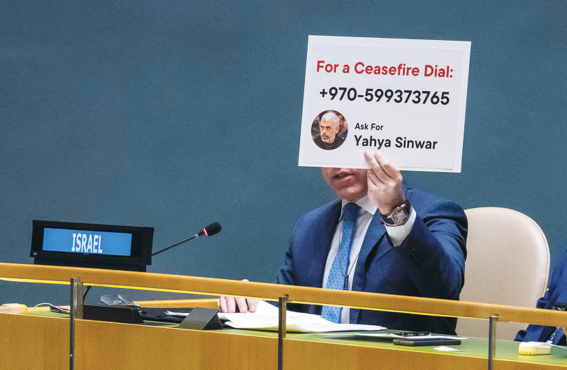  ISRAEL’S UN Ambassador Gilad Erdan holds up a sign, last Tuesday, with Hamas-Gaza leader Yahya Sinwar’s phone number, urging the assembled UN delegates to call him.  (photo credit: Eduardo Munoz/Reuters)