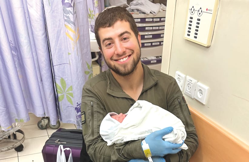  The writer holds his newborn son in the delivery room at Shaare Zedek hospital. (photo credit: ELIE MAYER)