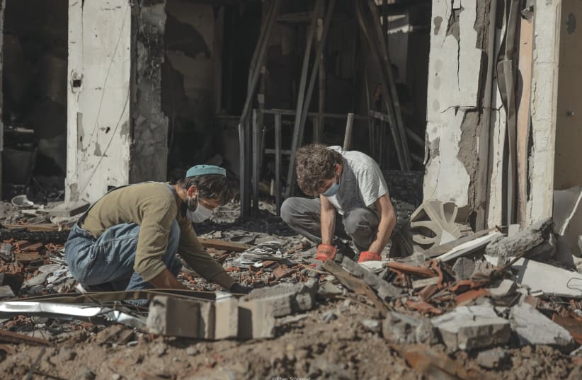  Members of a family, in which the father was murdered by Hamas terrorists on October 7, search in the rubble of his home in Kibbutz Be'eri for memories. The Middle East will no longer be the same, the writer asserts. (photo credit: CHEN SCHIMMEL/FLASH90)