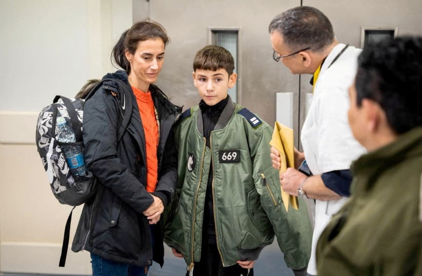  Eitan Yahalomi, 12, who was released from the Gaza Strip on November 27 after being taken hostage by the Palestinian terrorist group Hamas during the October 7 attack on Israel, is accompanied at Sourasky Medical Center (Ichilov) in Tel Aviv, Israel, on November 28, 2023. (photo credit: Israel Defense Forces/Handout via REUTERS)