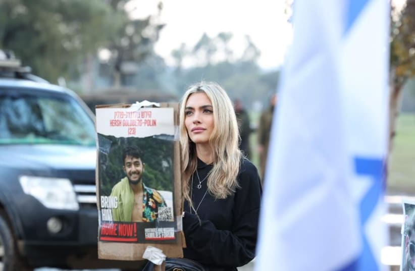  Emily Austin holds a sign depicting one of the Israeli hostages still held in Gaza (photo credit: ODED ANTMAN)