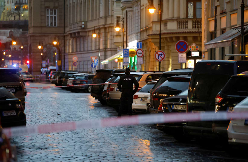 A police officer secures the area following the shooting at one of the buildings of Charles University in Prague, Czech Republic, December 21, 2023. (photo credit: DAVID W CERNY/REUTERS)