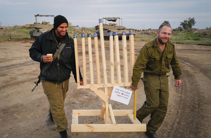  TRULY A book for the times: Soldiers carry a hanukkiah near the border with Syria, Dec. 8. (photo credit: MICHAEL GILADI/FLASH90)