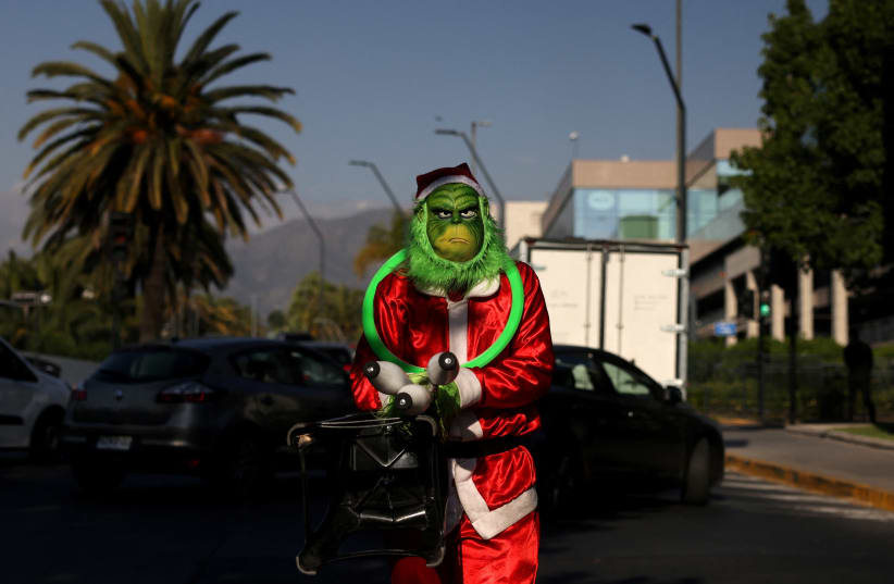A person dressed as the Grinch poses for a photo, during Christmas season in Santiago, Chile, December 20, 2023. (photo credit: IVAN ALVARADO/REUTERS)