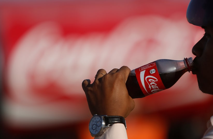  A man drinking Coca Cola, illustrative (photo credit: REUTERS/SAMRANG PRING)
