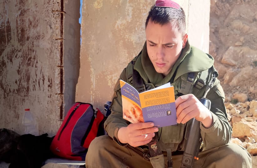  IDF soldiers holding special booklet by Rabbi Sacks (photo credit: The Rabbi Sacks Legacy)