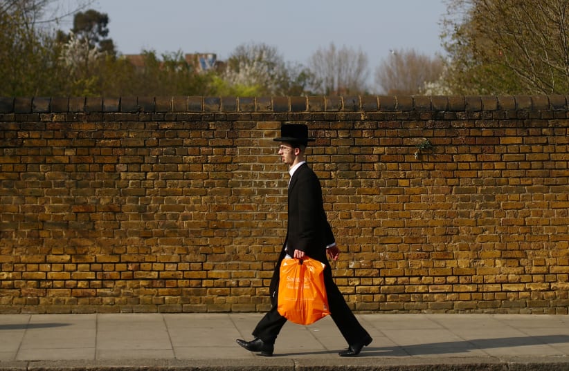  An Orthodox Jewish man is seen in Stamford Hill, as the spread of the coronavirus disease (COVID-19) continues, London, Britain, April 8, 2020. (photo credit: Hannah McKay/Reuters)