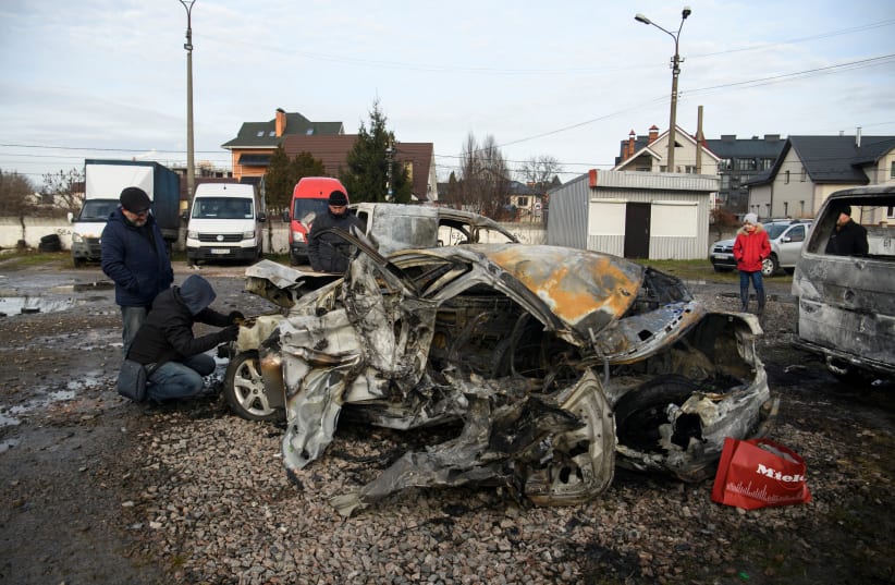  People inspect a car destroyed during a Russian missile and drone strike, amid Russia's attack on Ukraine, in Kyiv, Ukraine December 29, 2023. (photo credit: REUTERS/VLADYSLAV MUSIIENKO)