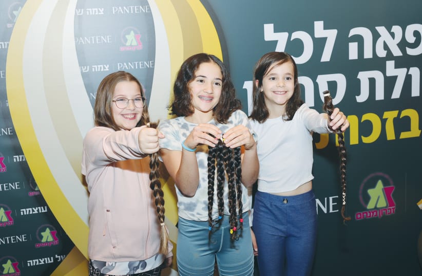  THREE GIRLS proudly show their hair donations. The bat-mitzvah age is the most common for hair donations. (photo credit: RAFI DELOYA)