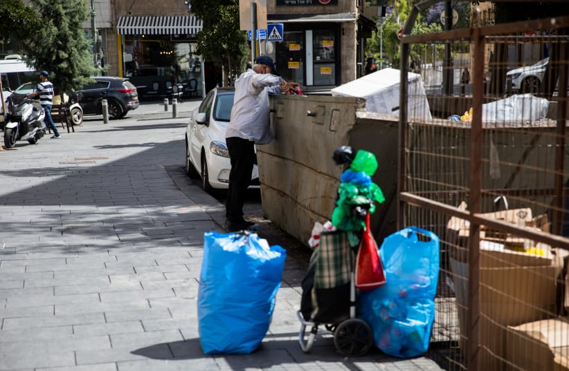 A man search in a trash bean in the city center of Jerusalem on June 02 2020. (photo credit: NATI SHOHAT/FLASH90)