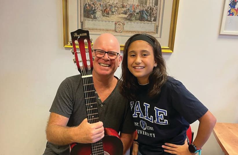  Shay Alon, guitar teacher at the Israel Conservatory of Music, with his evacuee student Roni Shamir (photo credit: Hadas Kaplan/Israel Conservatory of Music)