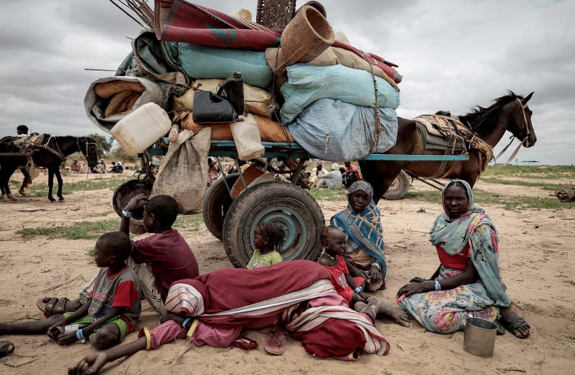  A Sudanese family who fled the conflict in Murnei in Sudan's Darfur region, sit beside their belongings while waiting to be registered by UNHCR upon crossing the border between Sudan and Chad in Adre, Chad, July 26, 2023.  (photo credit: REUTERS/ZOHRA BENSEMRA)