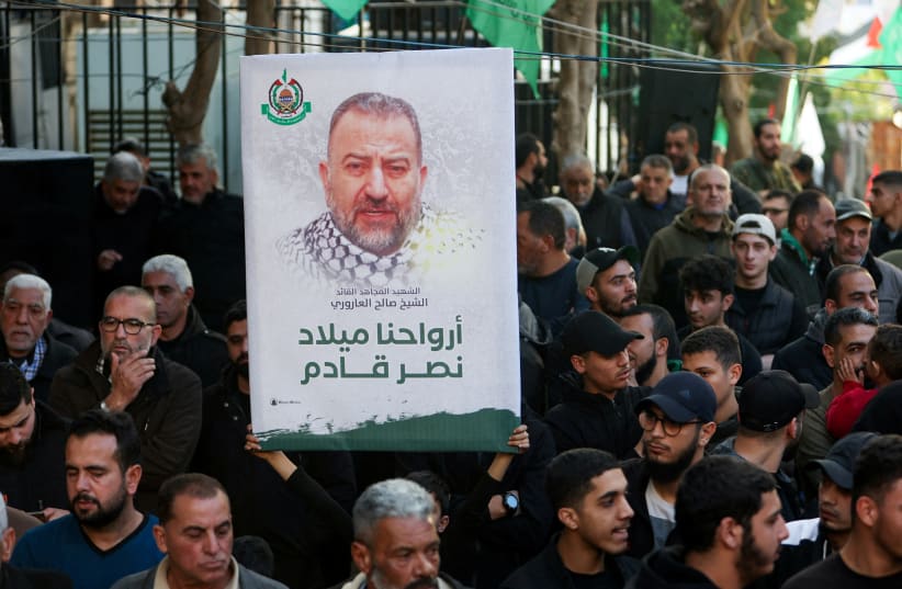  A person holds a placard displaying the photo of late Hamas deputy leader Saleh al-Arouri during the funeral of Ahmad Hammoud, who was killed along with al-Arouri in what security sources said was an Israeli drone strike in Beirut on Tuesday, in Burj al-Shemali in Tyre, Lebanon, January 3, 2024 (photo credit: AZIZ TAHER/REUTERS)