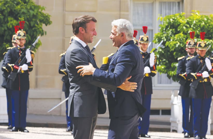  FRENCH PRESIDENT Emmanuel Macron welcomes then Israeli prime minister Yair Lapid as he arrives for a meeting at the Elysee Palace in Paris in 2022.  (photo credit: JOHANNA GERON/REUTERS)
