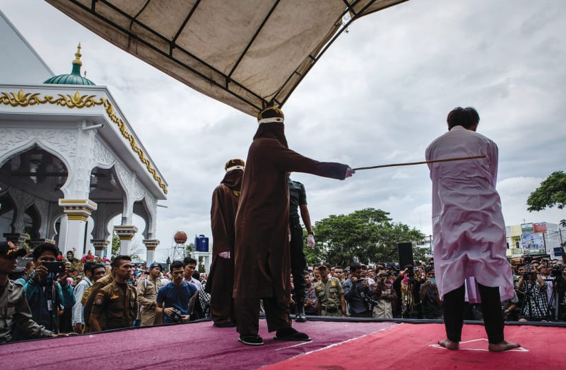  PUBLIC PUNISHMENT for engaging in homosexual acts, which is against Sharia law, at a mosque in Banda Aceh, Indonesia, 2017. (photo credit: ULET IFANSASTI/GETTY IMAGES)