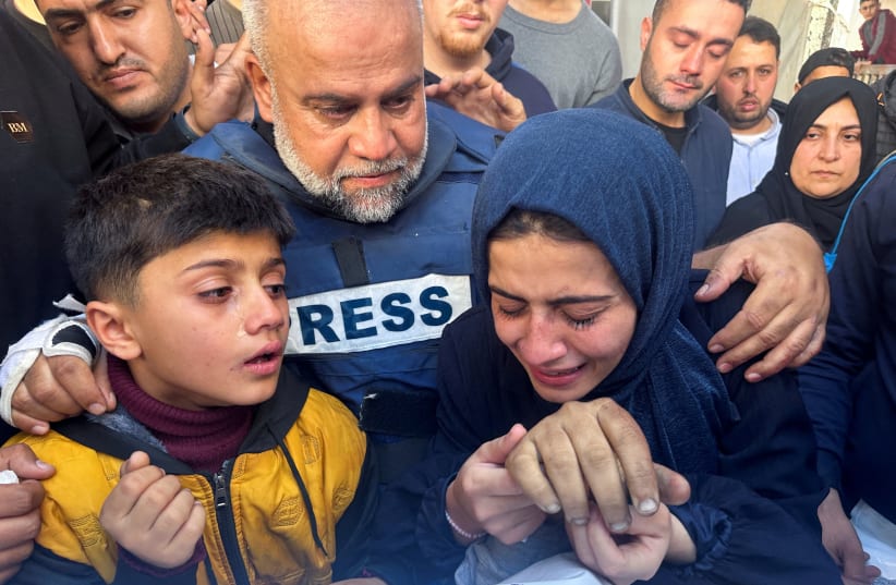  Al Jazeera journalist Wael Al-Dahdouh hugs his daughter and son as they attend the funeral of his son, Palestinian journalist Hamza Al-Dahdouh, after Hamza was killed in an Israeli strike, in Rafah in the southern Gaza Strip, January 7, 2024.  (photo credit: REUTERS/MOHAMMED SALEM)