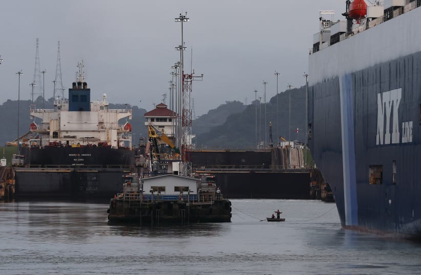  DOCK WORKERS on a small rowing boat pull a rope between the dock and vehicle carrier ‘Sirius Leader’ as it prepares to enter the Miraflores locks while transiting the Panama Canal last September. (photo credit: Justin Sullivan/Getty Images/TNS)