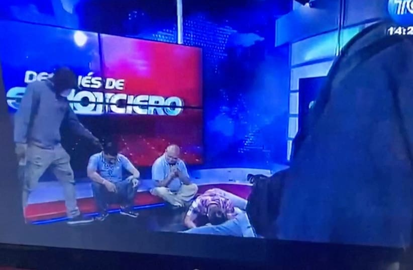  Workers lie on the floor as hooded and armed people take over a tv studio of Ecuador's TV station TC during a live broadcast, in this still image of a Reuters' recording of the affair of TC signal channel, in Guayaquil, Ecuador, January 9, 2024.  (photo credit: REUTERS TV/via REUTERS)