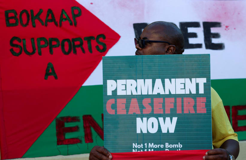  A man holds a placard which accuses Israel of genocide in the Gaza war, at the International Court of Justice in the Hague, in Cape Town, South Africa, January 10, 2024 (photo credit: REUTERS/ESA ALEXANDER)