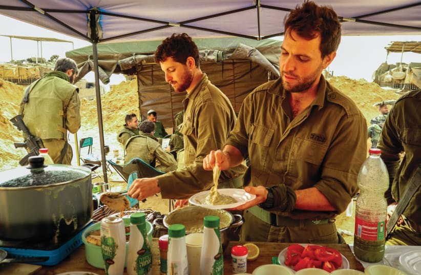  Reservists Stav Netta-Chaim (L) and Niv Ishay prepare hummus from combat rations in Gaza (photo credit: Shaked Brand)